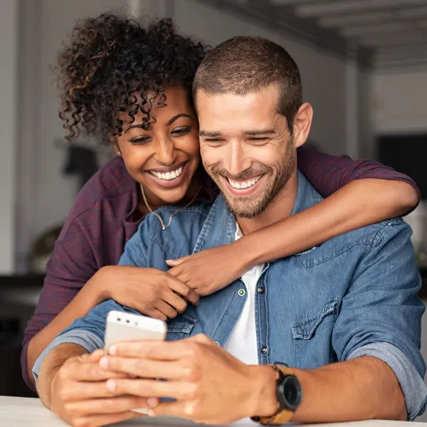 Couple Exploring Financing Options On Cell Phone